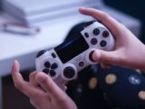 person holding white and black game controller