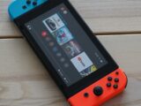 an orange and blue nintendo switch sitting on top of a wooden table