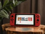 red nintendo switch on brown wooden table