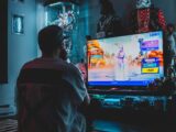 man in red shirt watching tv