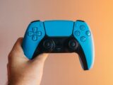 a person holding a blue video game controller