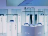 PlayStation 5 consoles and accessories on display in a sleek, futuristic showroom.