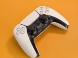 White video game controller on orange background