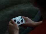 a close up of a person holding a controller