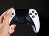 a close up of a person holding a video game controller