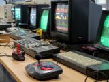 a row of computer monitors sitting on top of a desk