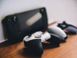Stylish setup of gaming controllers and console on wooden surface.