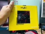 A person holding up a yellow box with a picture on it