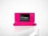a pink nintendo ds sitting on top of a white table