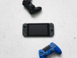 Flat lay of gaming consoles and controllers on white surface, featuring popular gaming devices.