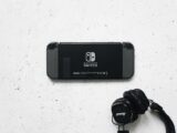 Nintendo Switch and headphones on a minimalist marble background, perfect for gaming content.
