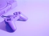 gray Sony PlayStation console with corded controller