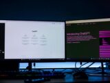 Dual computer monitors showcasing a chat interface in a technology workspace setting.