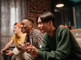 Diverse group of young adults enjoying video games together indoors, creating a fun and social atmosphere.