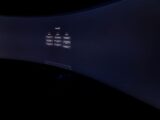 Curved monitor screen showing ChatGPT interface in low-light, focus on technology and AI.