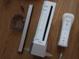 a nintendo wii game system sitting on top of a wooden table