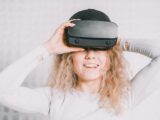 Smiling woman wearing a VR headset and experiencing virtual reality excitement.