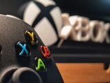 Detailed view of Xbox gaming controller with vibrant buttons displayed indoors.