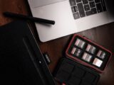 Close-up view of a workspace featuring a laptop, drawing tablet, and memory cards.