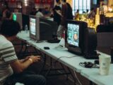 Adults enjoying a retro gaming event with CRT televisions and consoles, creating a nostalgic atmosphere indoors.