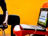 a man sitting in a chair with a laptop on his lap