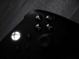 Monochrome close-up of a gaming controller highlighting buttons and logo.